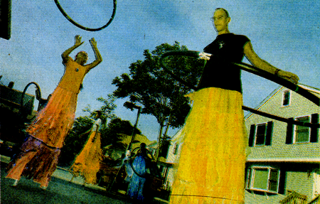 people on stilts with hola hoops